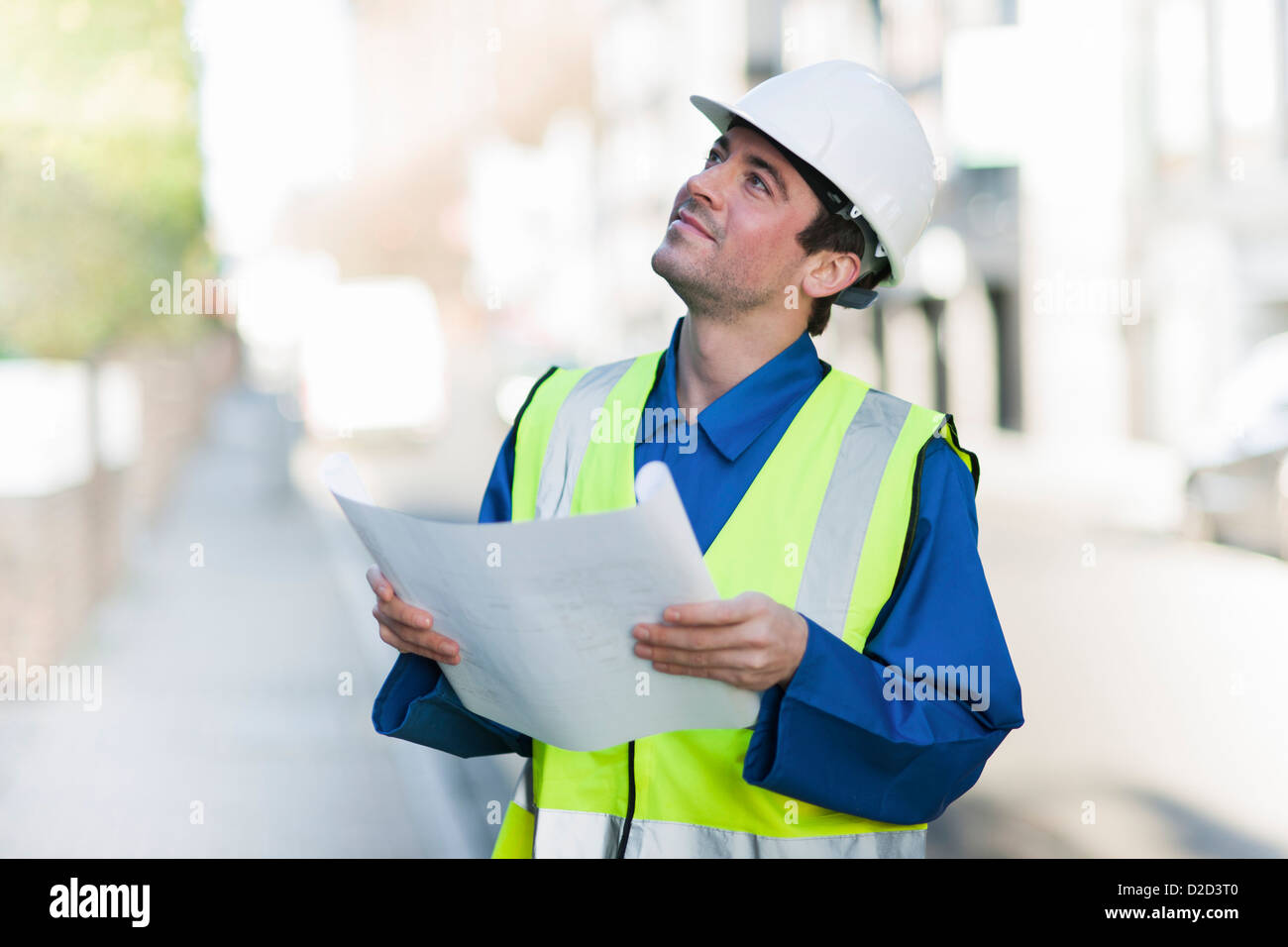 Modello rilasciato lavoratore edile che indossa un elmetto e una elevata visibilità camicia Foto Stock