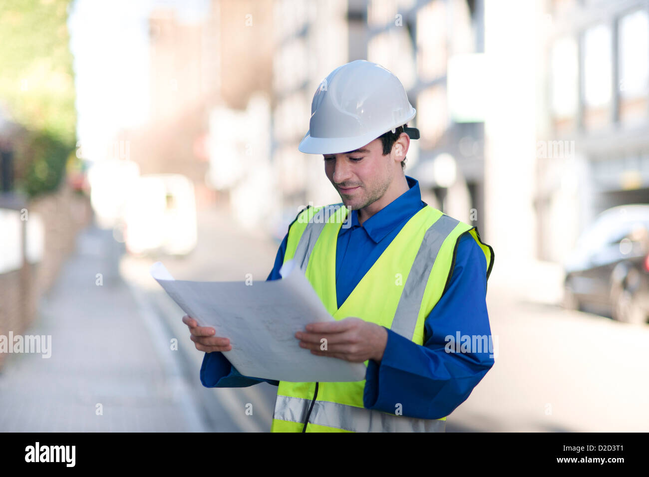 Modello rilasciato lavoratore edile che indossa un elmetto e una elevata visibilità camicia Foto Stock