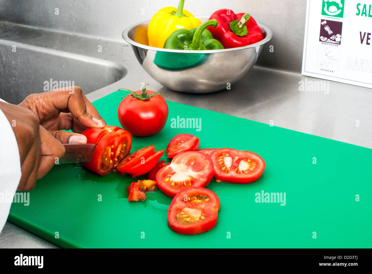 Modello rilasciato il taglio di lavorazione dei pomodori Pomodori di taglio sulle opportune codificati per colore bordo Foto Stock