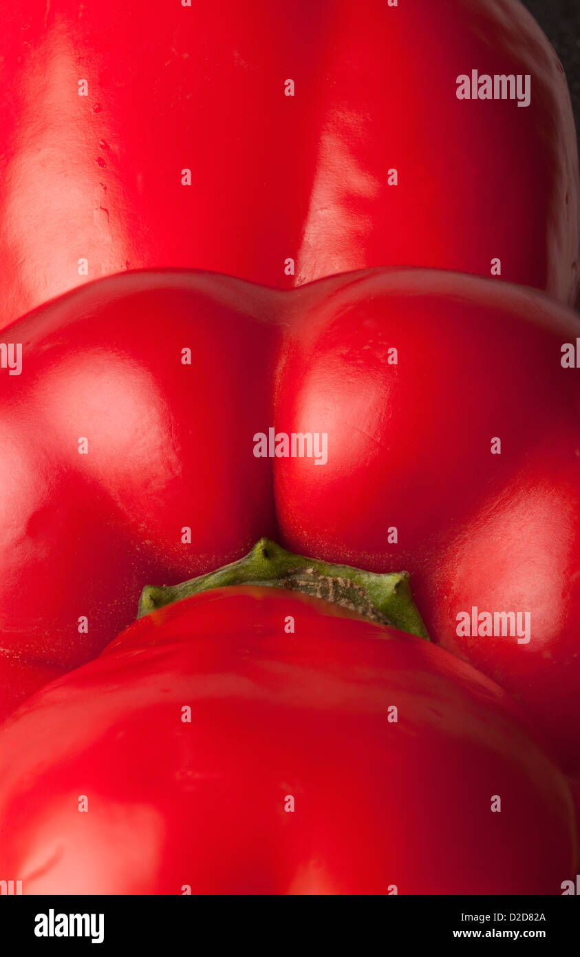 Tre peperoni rossi disposti in una fila Foto Stock