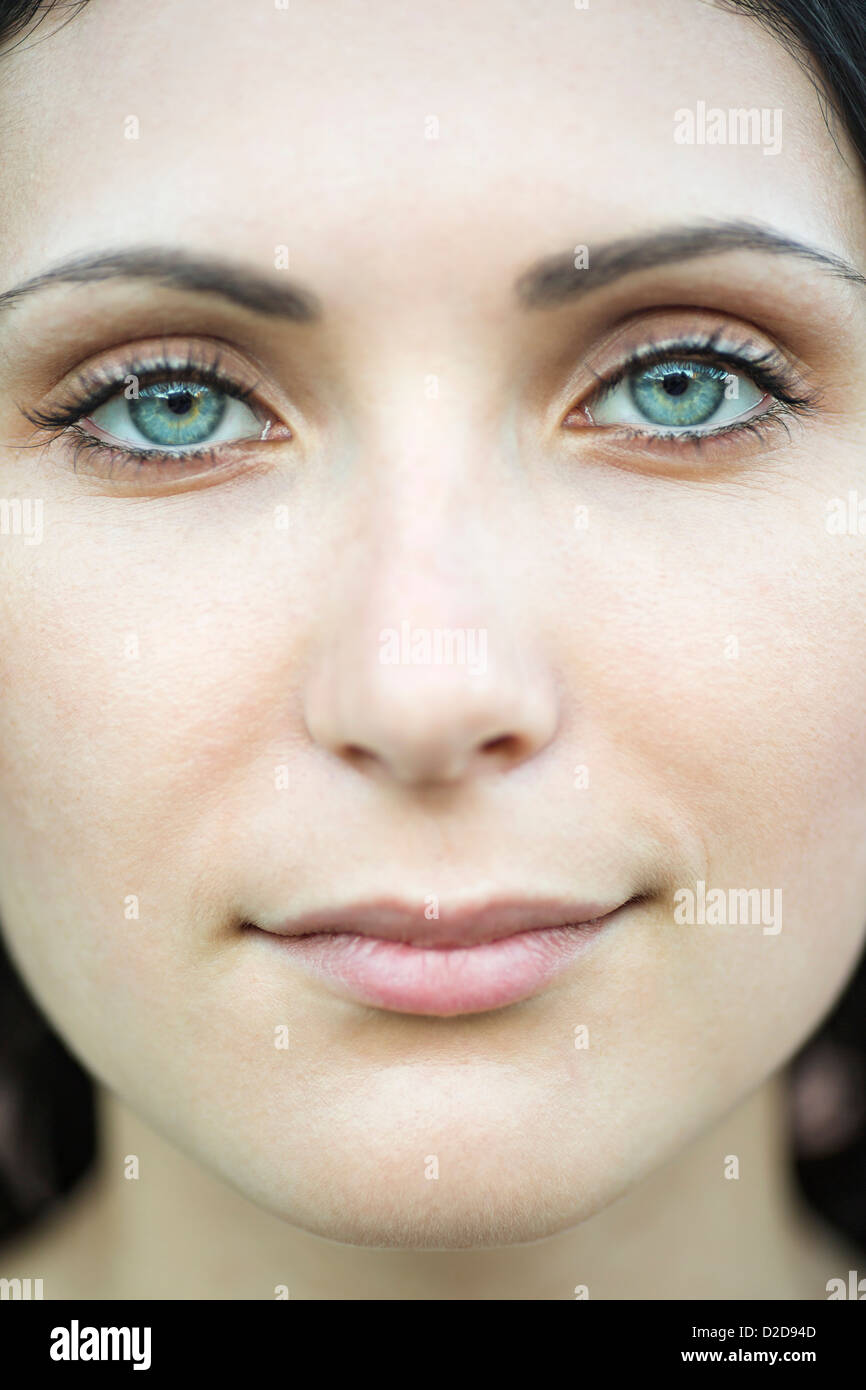 Una bella donna staring serenamente nella fotocamera, close-up di faccia Foto Stock