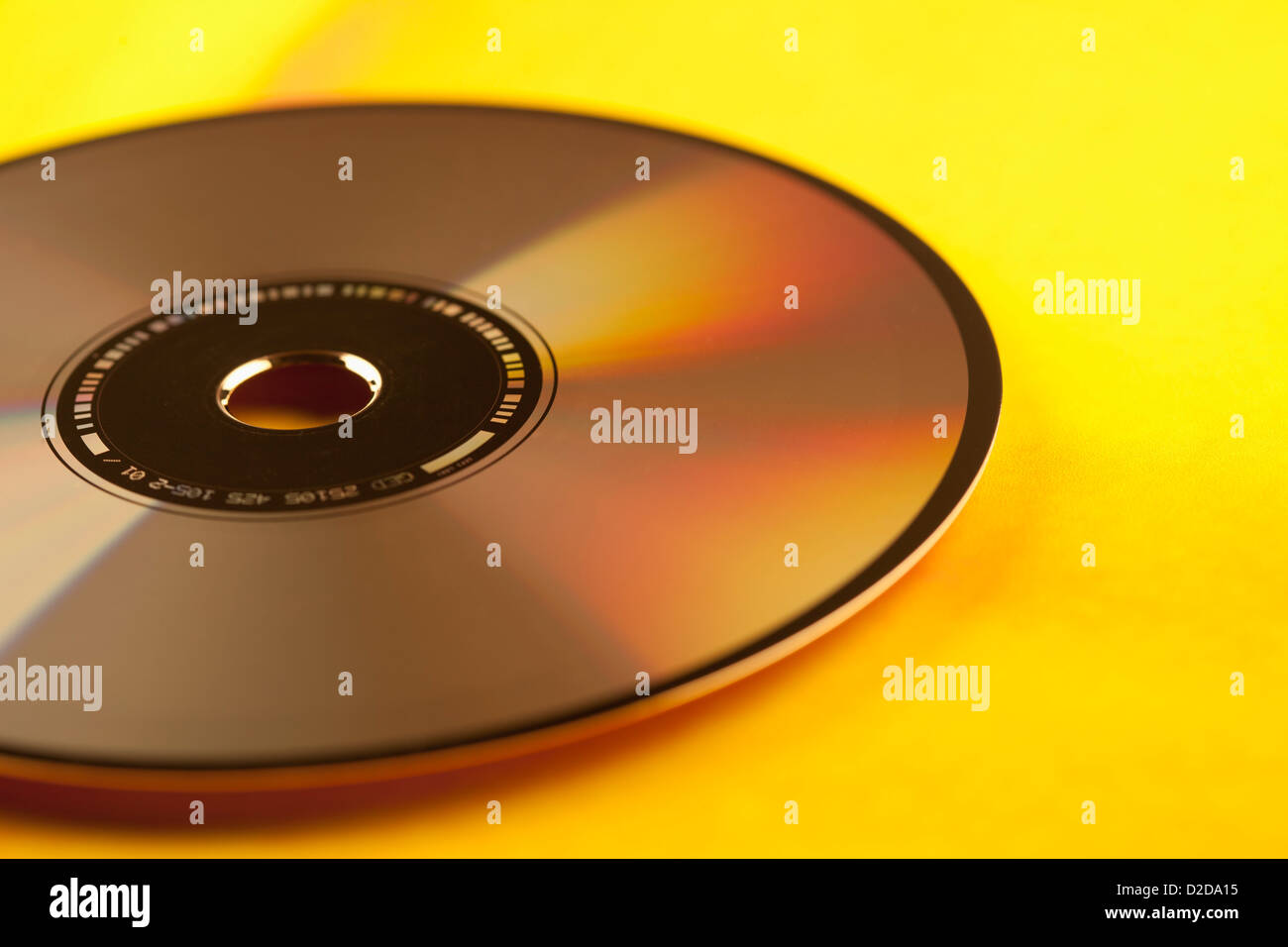 Un singolo disco compatto su uno sfondo giallo, close-up Foto Stock