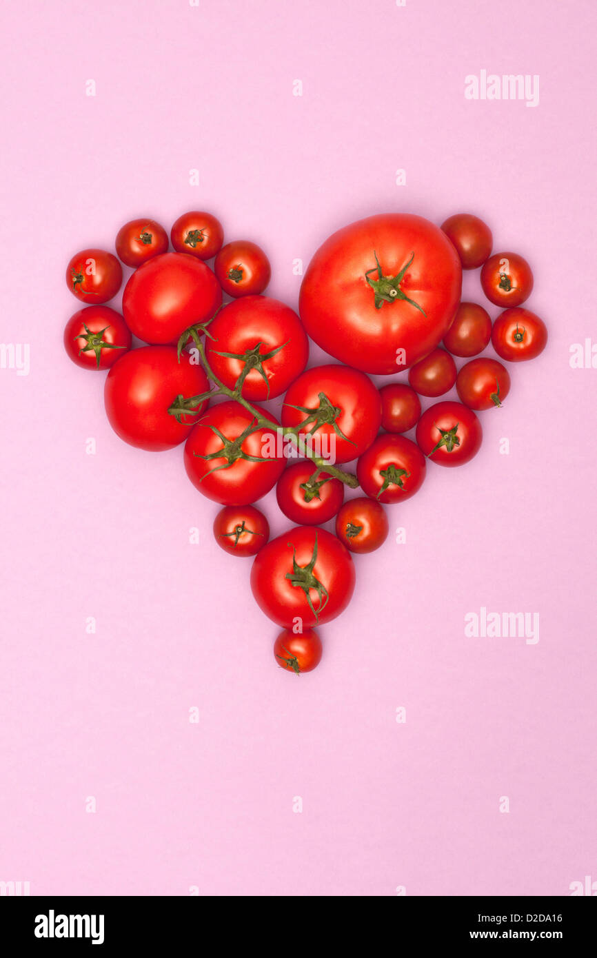Vari formati di pomodori disposti in forma di cuore Foto Stock