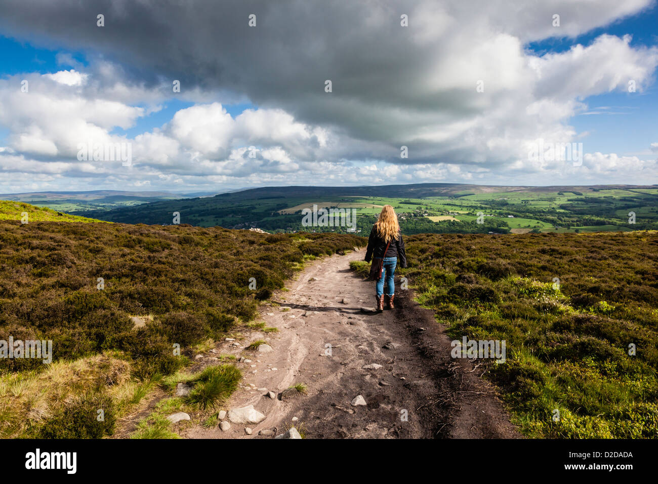 Donna attraente si ammira la vista sul modo Dales, attraverso la parte superiore di Ilkley Moor Foto Stock
