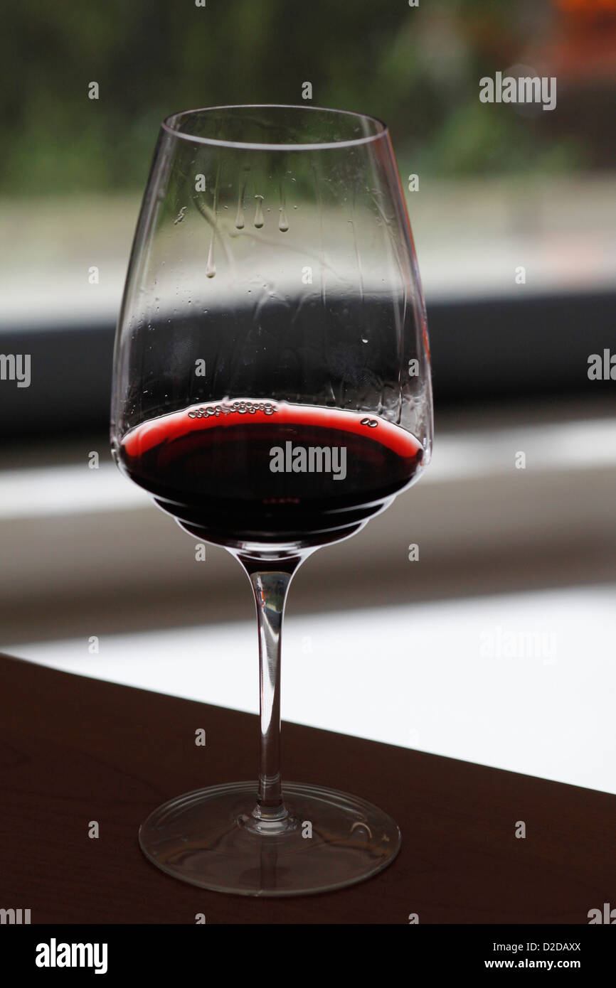 Un bicchiere di vino rosso con vino gambe Foto Stock