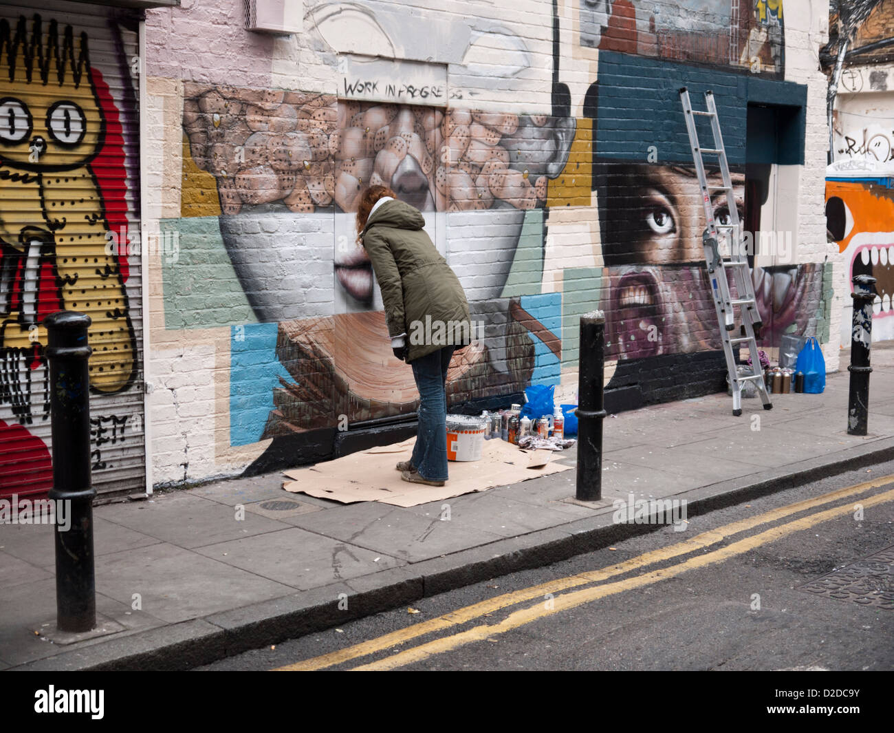 Artisti - Bom K e Liliwenn - lavorando su arte di strada in Hanbury Street, Off Brick Lane, Londra Foto Stock