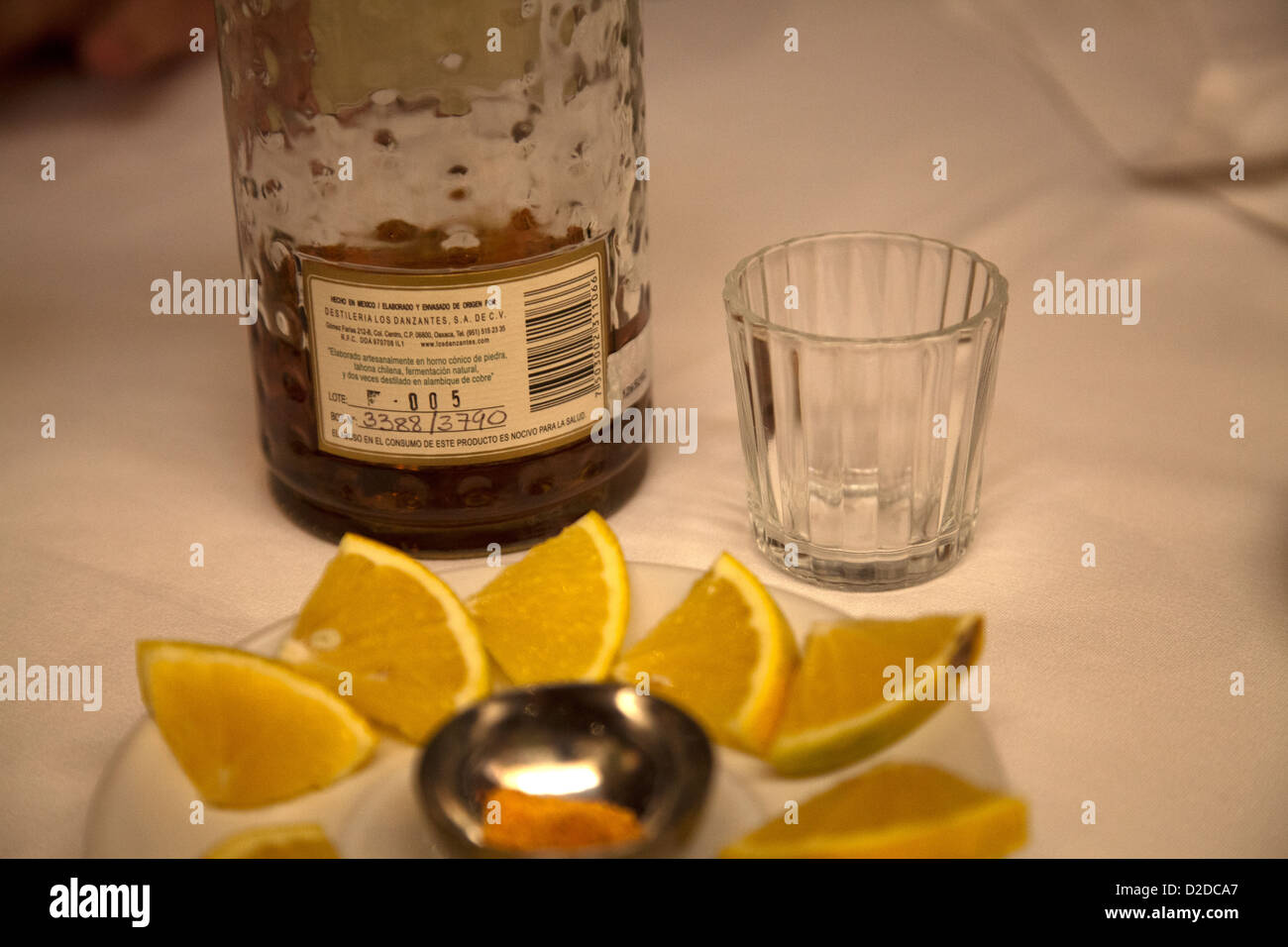 Los Danzantes Mezcal servito con spicchi di limone e polvere di sale di worm - numero di lotto sul retro della bottiglia Foto Stock