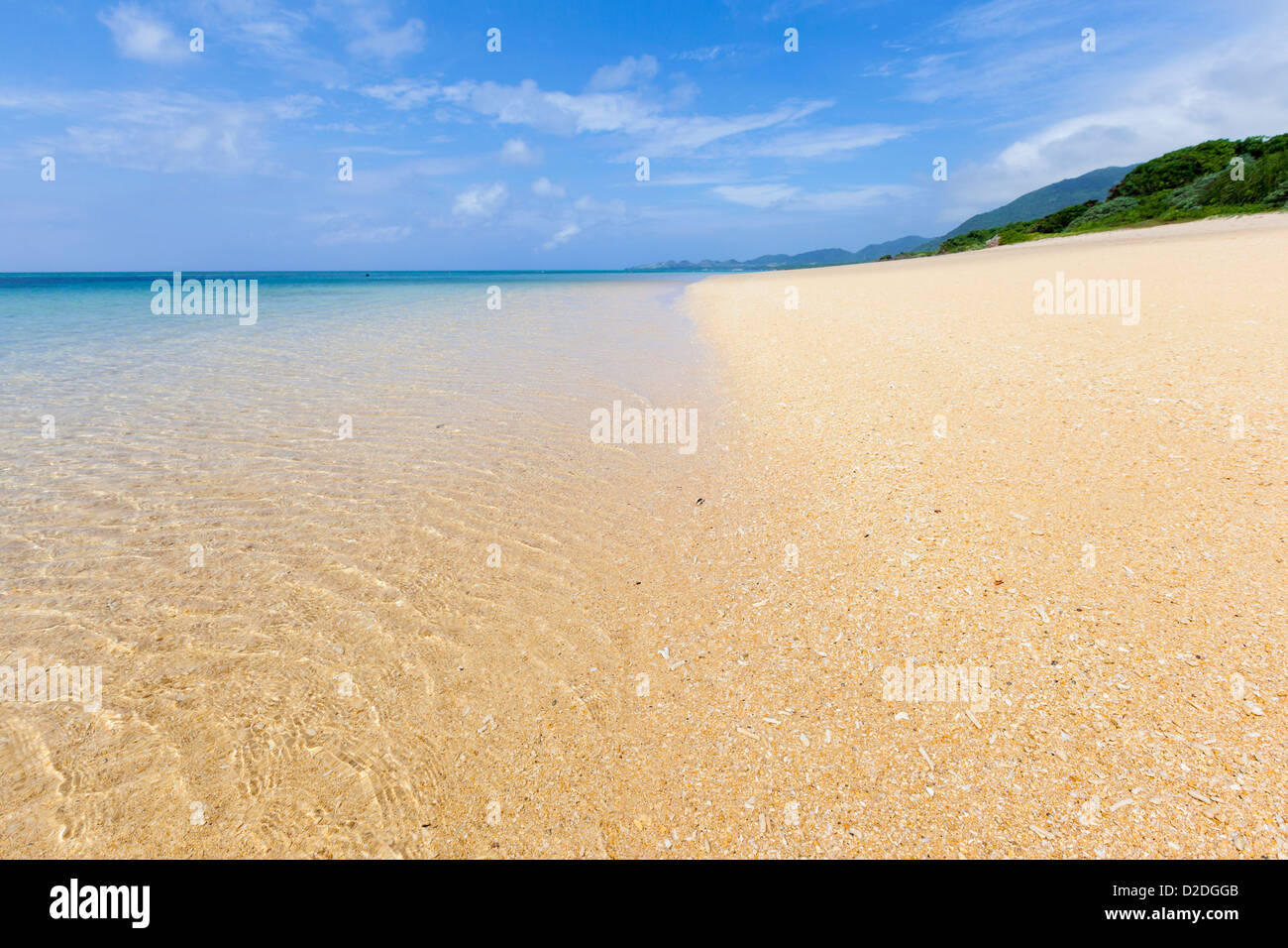 Spiaggia di sabbia e acque turchesi su un isola tropicale. Il fuoco selettivo sulla spiaggia in primo piano. Foto Stock