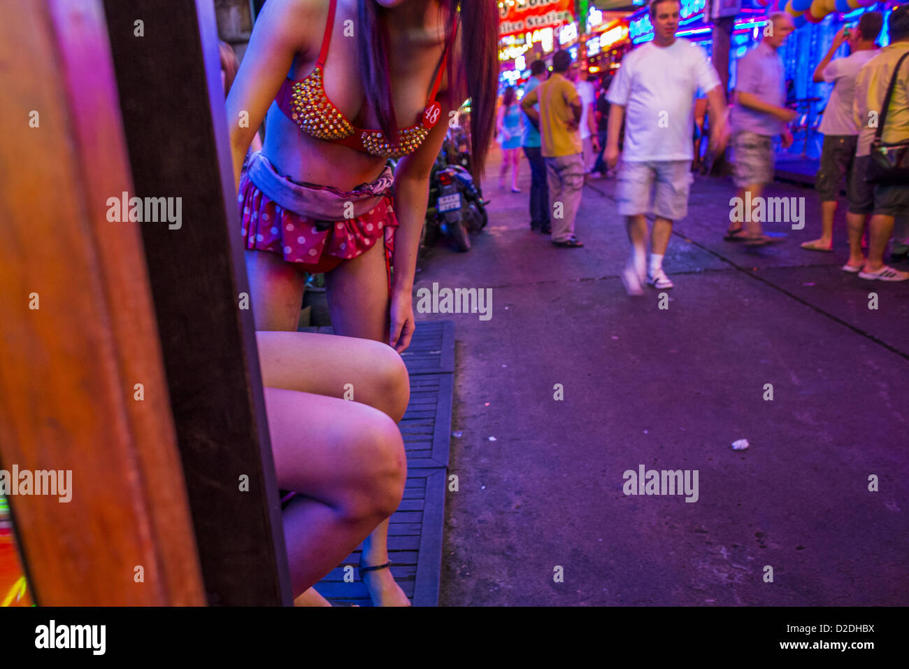 Gen 12, 2013 - Bangkok, Thailandia - Ladyboy (transgendered) animatori cercano di attirare i clienti nel Cacatua bar in Soi Cowboy quartiere a luci rosse di Bangkok. In Thai, la ladyboys sono chiamati kathoey. Molti lavorano in divertimento e vita notturna e settori dell'economia thailandese. La prostituzione in Thailandia è illegale, anche se in pratica è tollerata e in parte disciplinati. La prostituzione è attuata apertamente in tutto il paese. Il numero di prostitute è difficile da determinare, le stime variano ampiamente. Poiché la guerra del Vietnam, Thailandia ha acquisito una notorietà internazionale tra i viaggiatori da Foto Stock