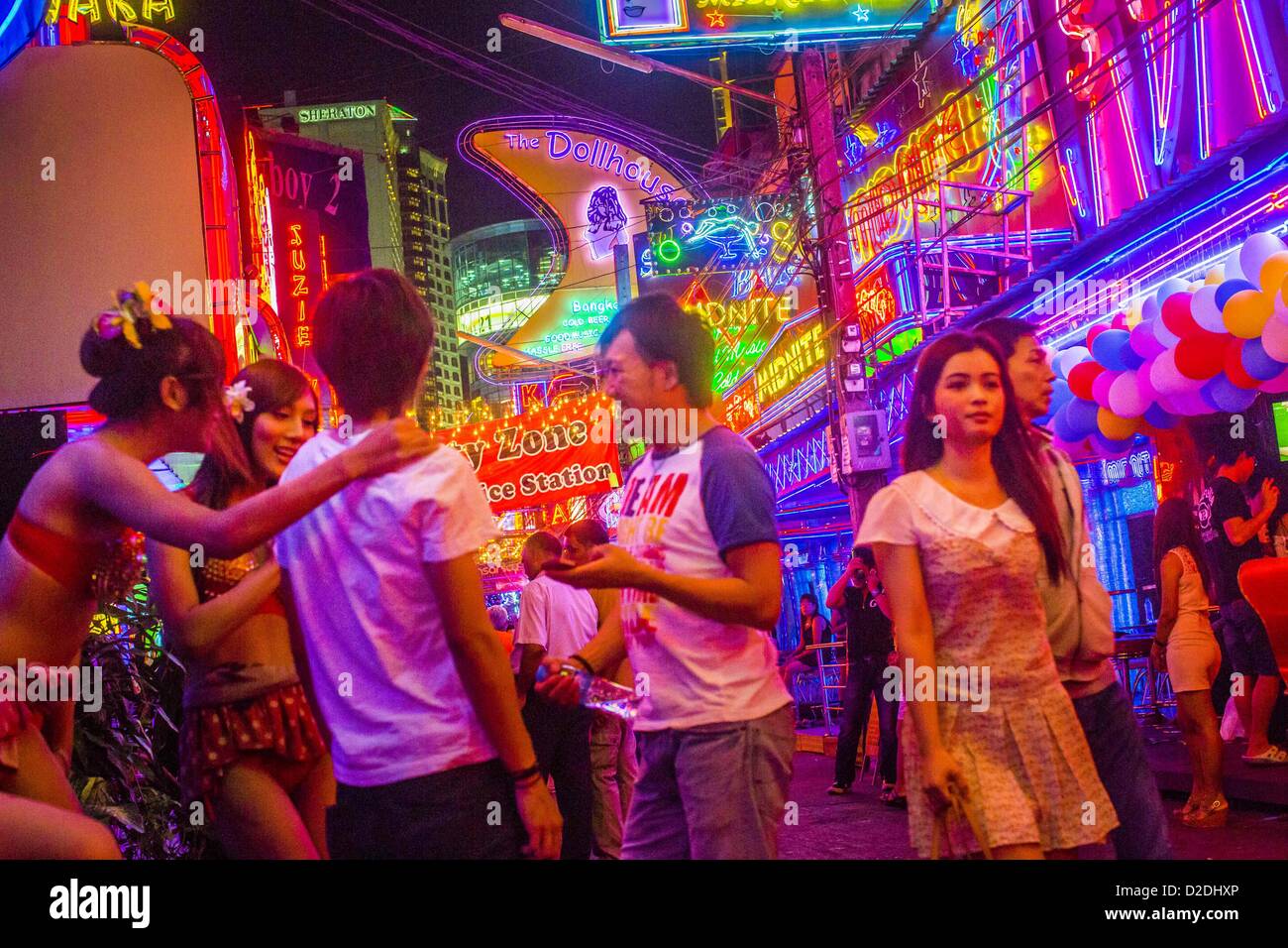Gen 12, 2013 - Bangkok, Thailandia - Ladyboy (transgendered) animatori flirt con i clienti cercano di attirare nell'Cacatua bar in Soi Cowboy quartiere a luci rosse di Bangkok. In Thai, la ladyboys sono chiamati kathoey. Molti lavorano in divertimento e vita notturna e settori dell'economia thailandese. La prostituzione in Thailandia è illegale, anche se in pratica è tollerata e in parte disciplinati. La prostituzione è attuata apertamente in tutto il paese. Il numero di prostitute è difficile da determinare, le stime variano ampiamente. Poiché la guerra del Vietnam, Thailandia ha acquisito una notorietà internazionale tra Foto Stock