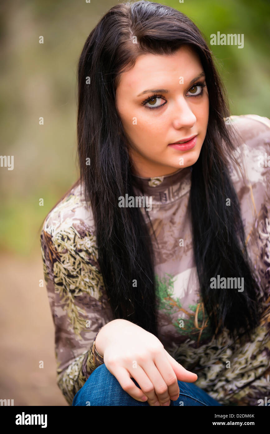 Outdoor ritratto di adolescente di sesso femminile, 18 anni, caucasica, in camuffamento maglione e jeans denim Foto Stock