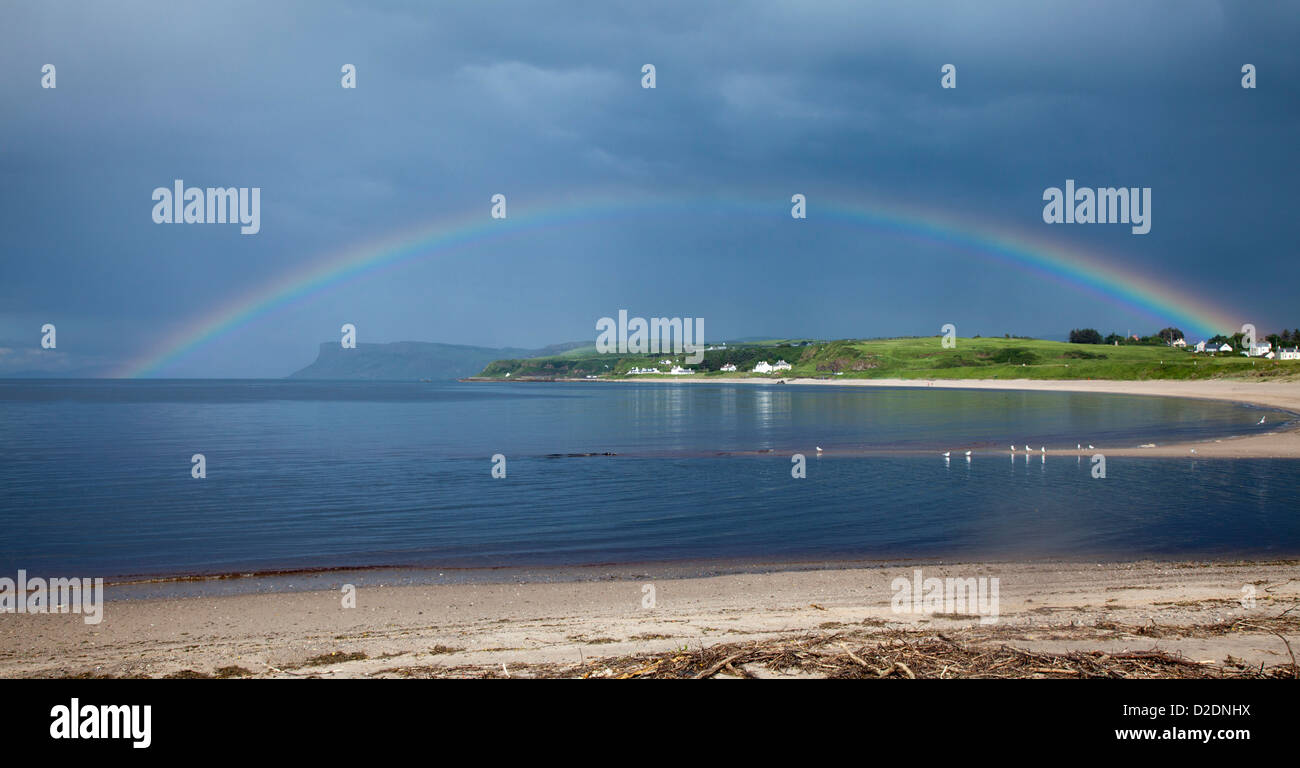 Rainbow attraverso Ballycastle Beach, nella contea di Antrim, Irlanda del Nord. Foto Stock