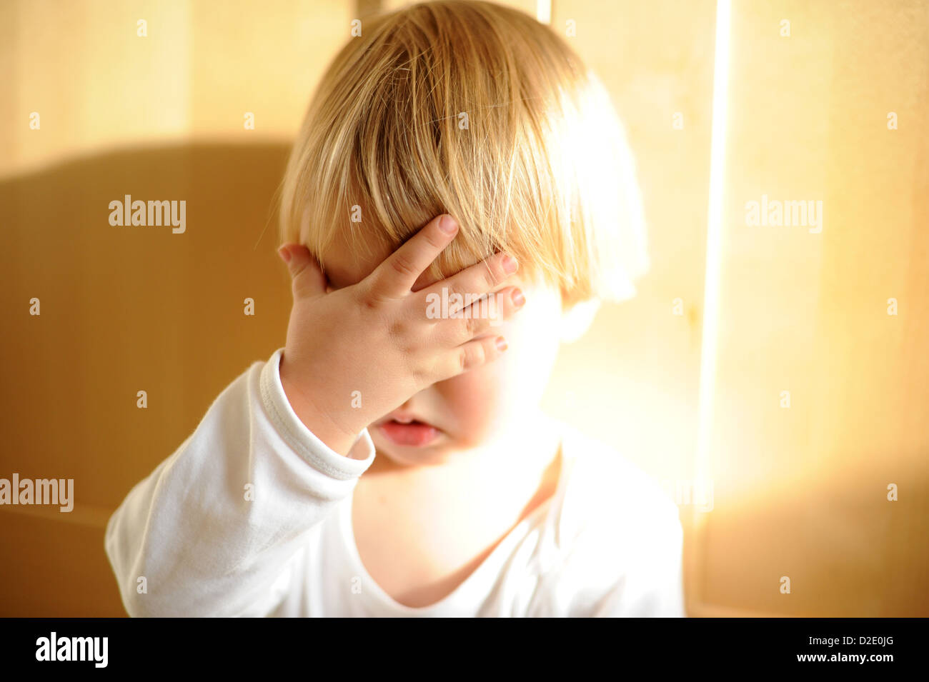 Berlino, Germania, a due anni e mezzo che old boy trattiene la sua mano per il suo volto Foto Stock