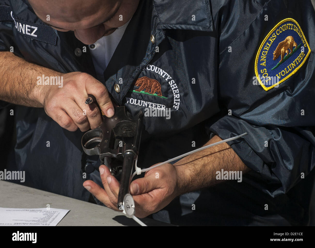 Gen 21, 2013 - Los Angeles, California (CA, Stati Uniti - una Los Angeles County Sheriff's vice controlla una pistola recuperata durante un ''doni per pistole'' exchange program in Los Angeles, California, 21 gennaio, 2013. La gente è in grado di ruotare in un'arma da fuoco e ricevere una carta regalo $200 per un fucile d assalto, $100 per una pistola, e $50 per un fucile da caccia. (Credito Immagine: © Ringo Chiu/ZUMAPRESS.com) Foto Stock