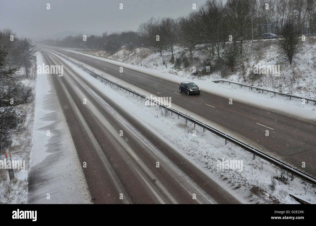 Una vettura viaggia lungo una coperta di neve in autostrada in Shropshire, Inghilterra Foto Stock