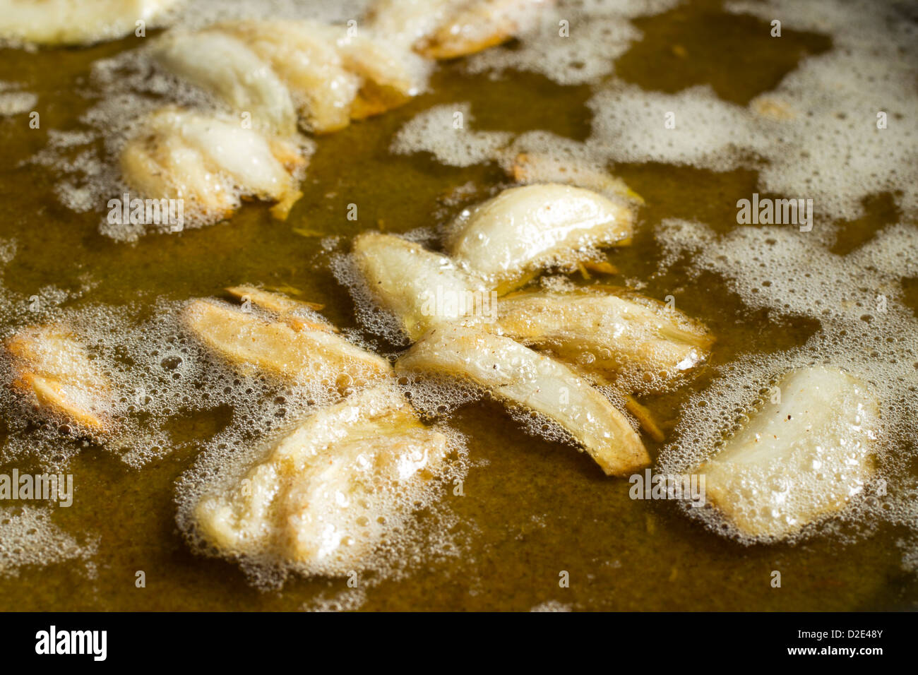 Fracassato spicchi di aglio e frittura in olio e burro Foto Stock