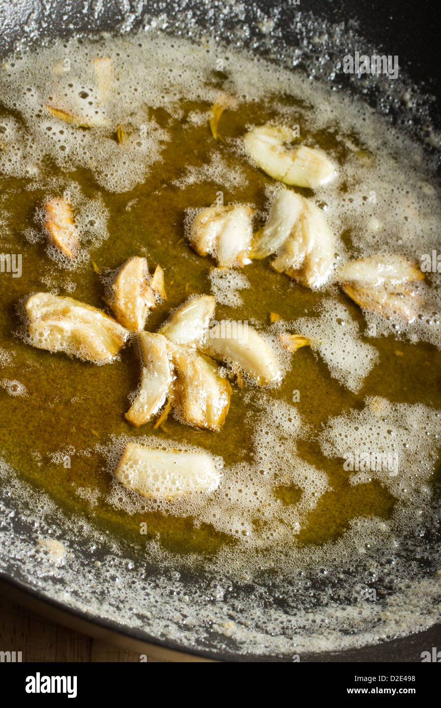 Fracassato spicchi di aglio e frittura in olio e burro Foto Stock