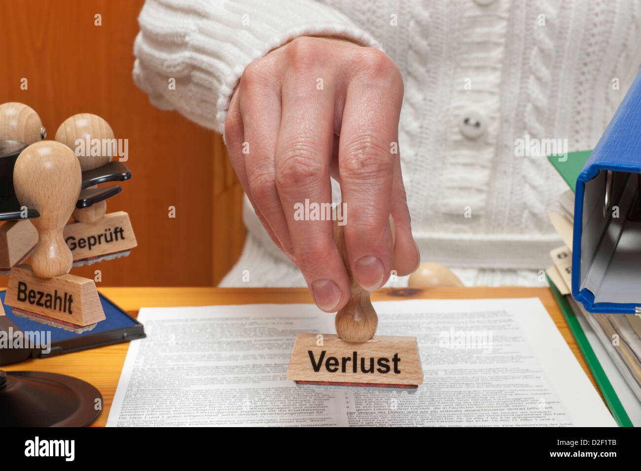 Un timbro con il tedesco iscrizione disavanzo è tenuto in mano Foto Stock
