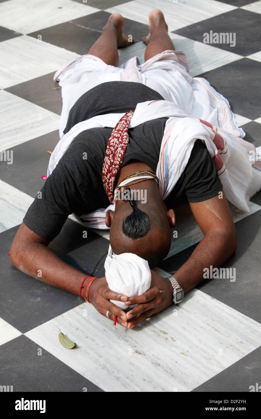 Hare Krishna devoto prosternating sul pavimento del tempio Vrindavan. India. Foto Stock