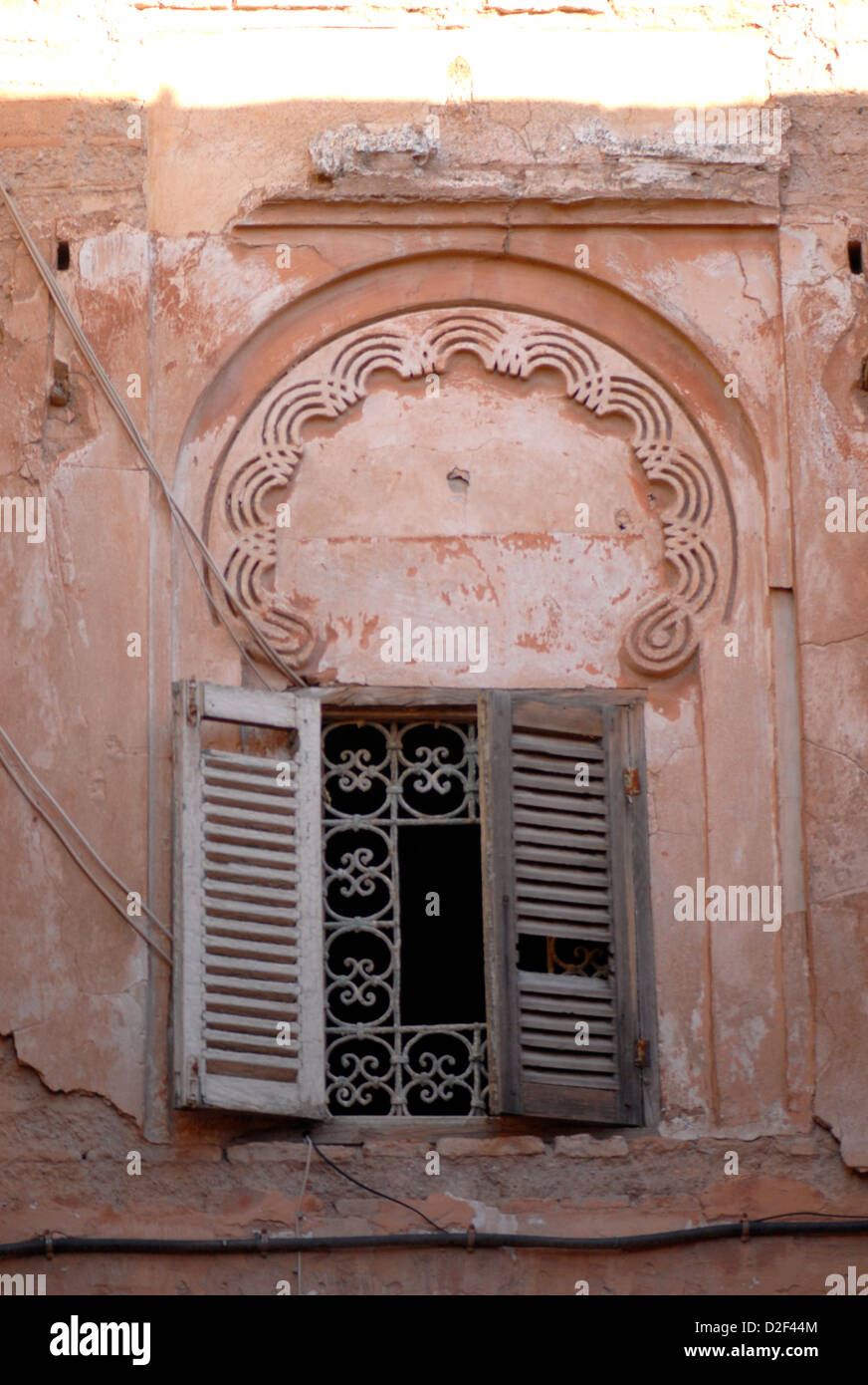 Ferro battuto finestra con persiane rotto sotto arco islamica nella medina marrakech marocco Foto Stock