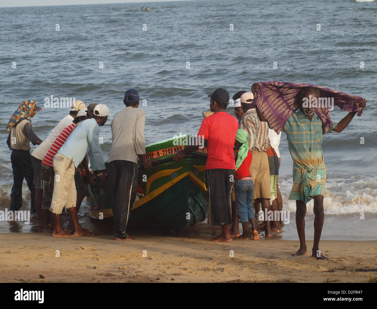 I pescatori a Negombo Sri Lanka sondaggio la cattura in una barca appena arrivati sulla spiaggia Foto Stock