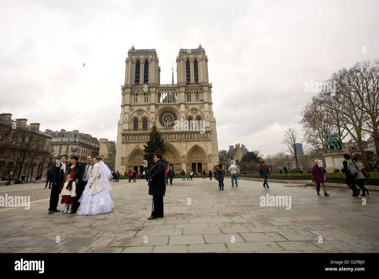 Una giornata nuvolosa alla cattedrale di Notre-Dame a Parigi, in Francia, con una coppia di nozze che posa per le fotografie in mezzo alla grandiosità di questo iconico monumento. Foto Stock