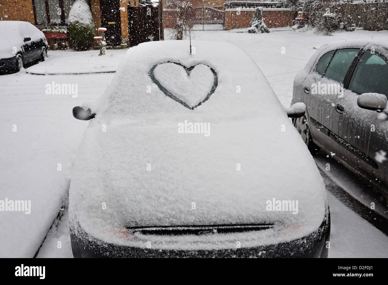 Auto con cuore disegnato nella neve sul parabrezza, Stanwell Moor, Surrey, England, Regno Unito Foto Stock