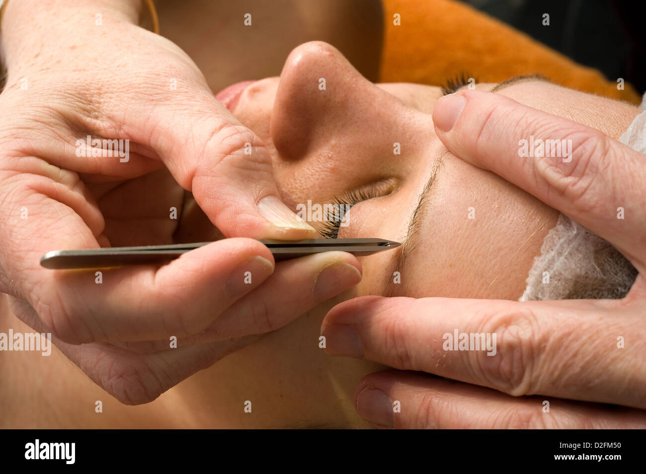 Donna di sopracciglio viene depilata in un salone di bellezza Foto Stock