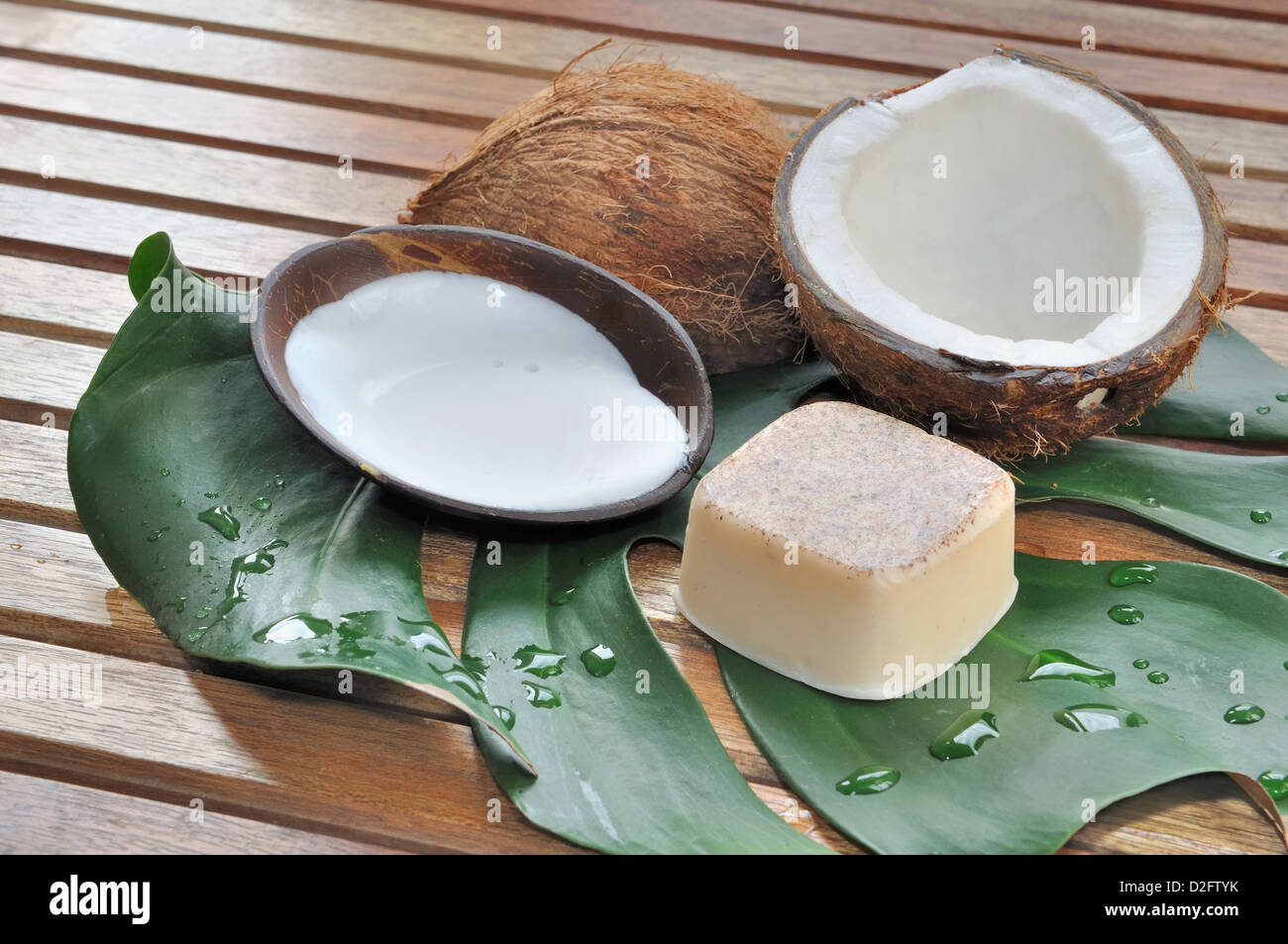Sapone e latte di cocco con noce di cocco disposti su un pallet di legno Foto Stock