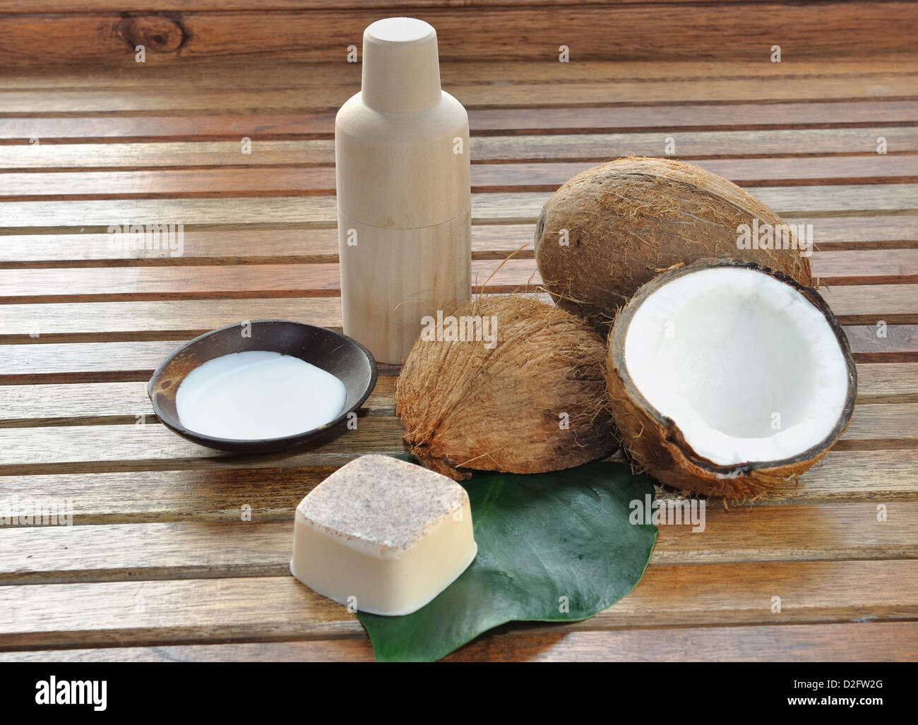 Sapone e latte di cocco con disposti su una panca in legno Foto Stock