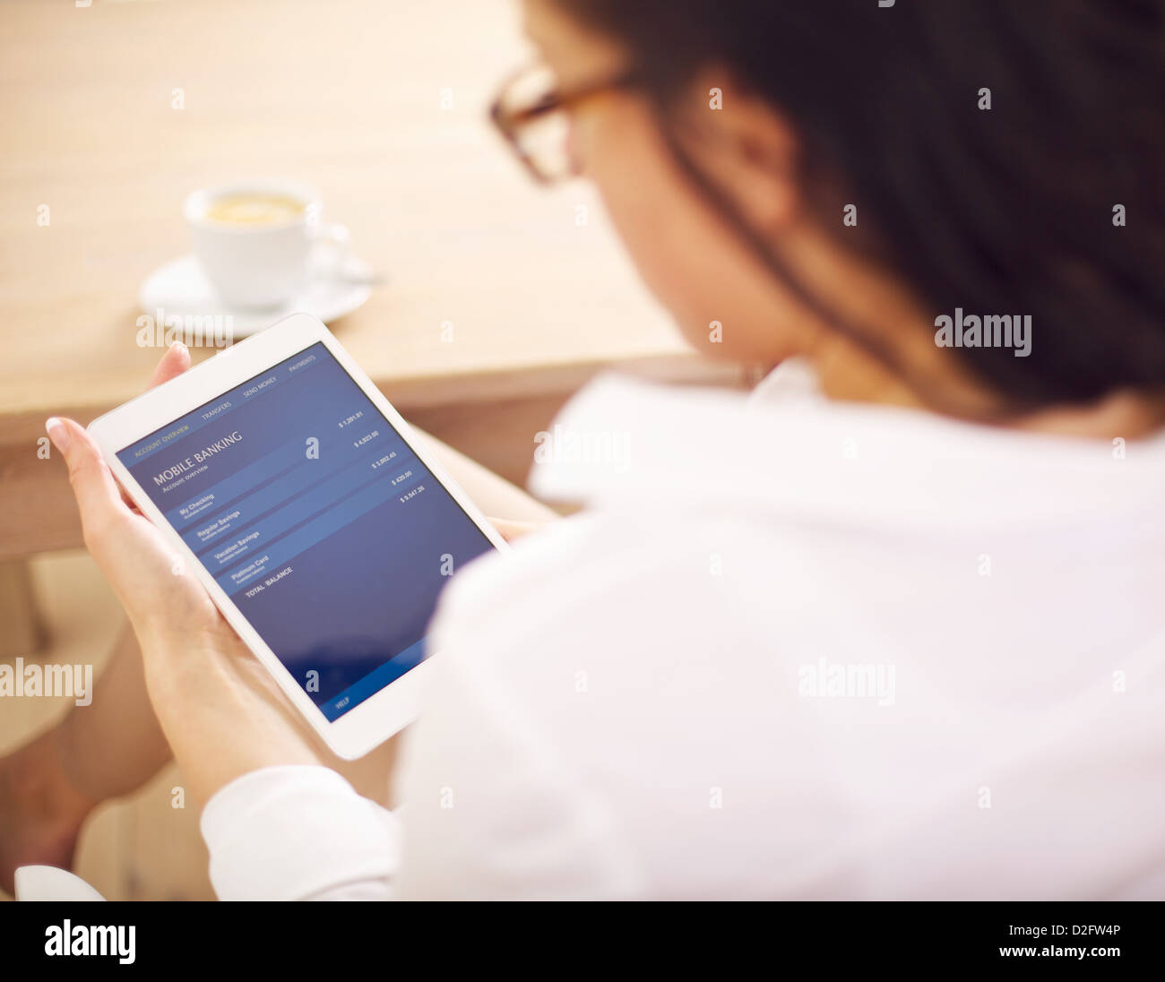 donna d'affari che controlla il suo conto in banca online usando il suo tablet digitale Foto Stock