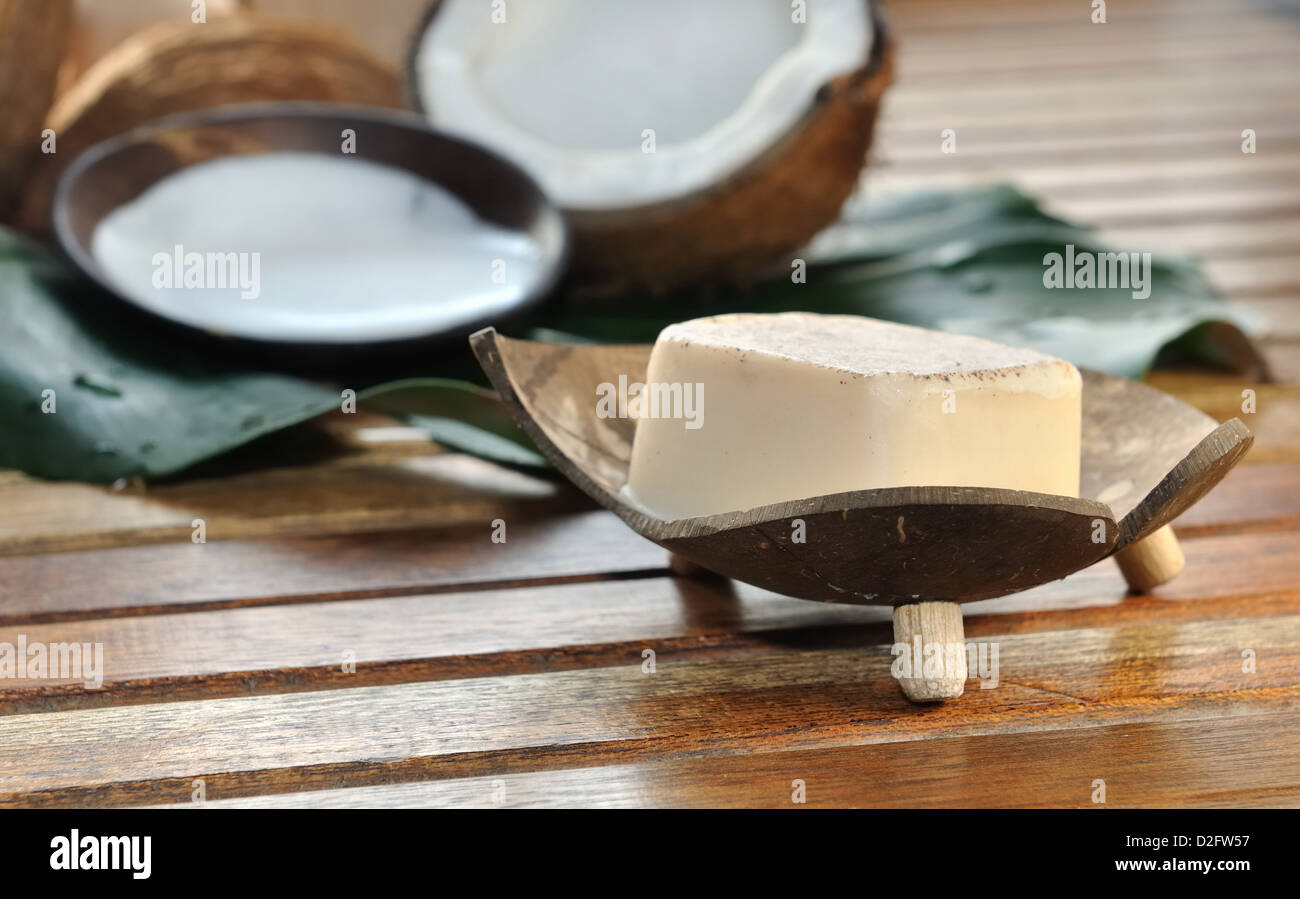 Sapone e latte di cocco con disposti su una panca in legno Foto Stock