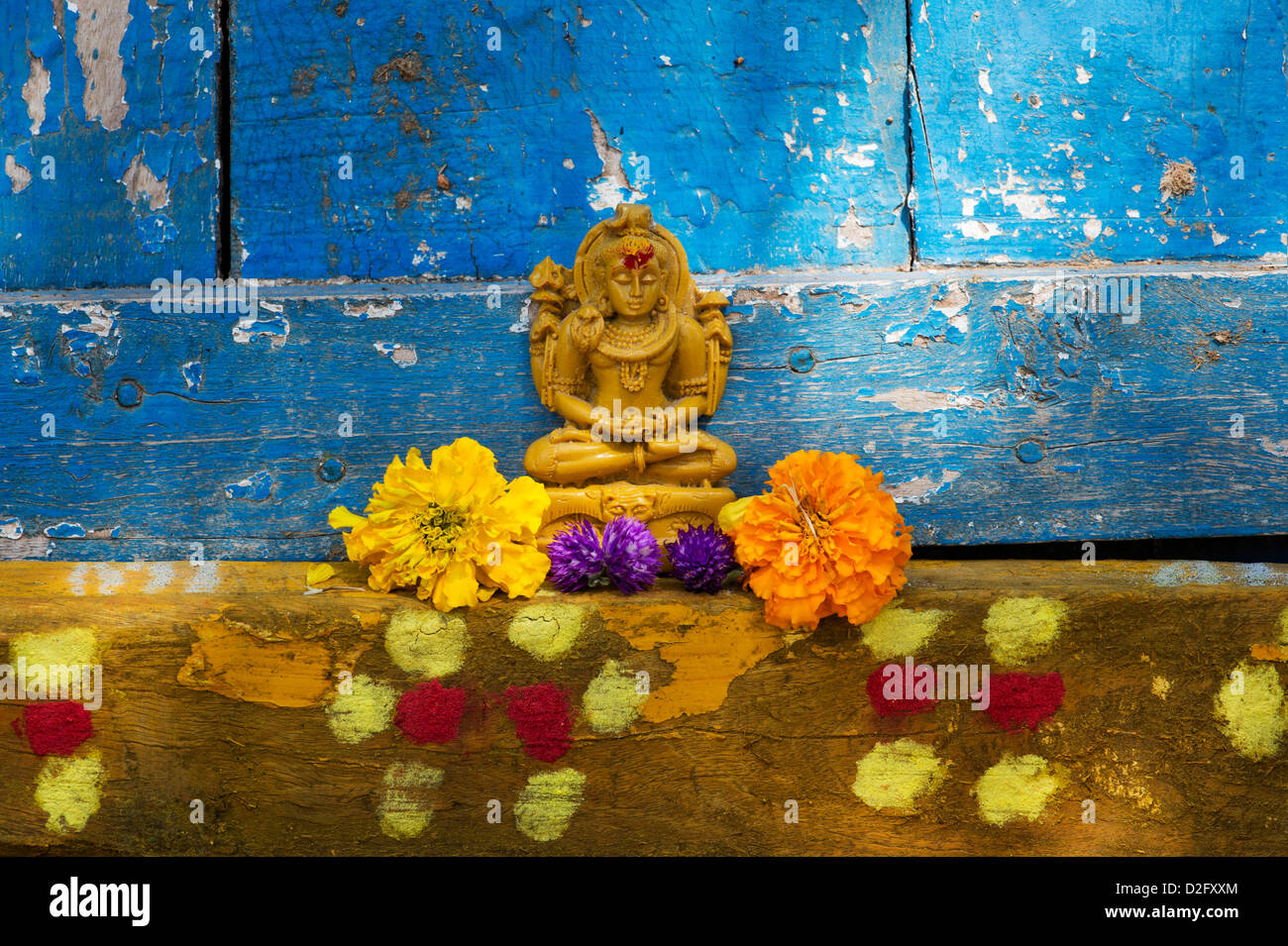 Signore Shiva statua e petali di fiori al di fuori del tempio del villaggio porta. India Foto Stock