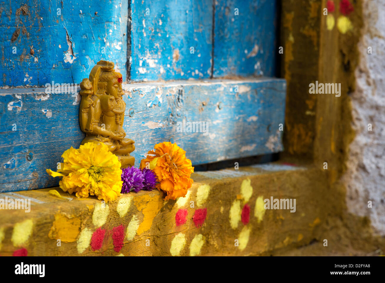 Signore Shiva statua e petali di fiori al di fuori del tempio del villaggio porta. India Foto Stock