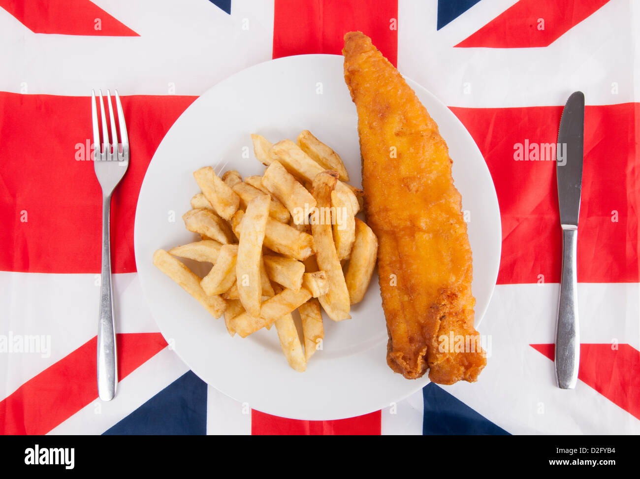 Close-up di junk food con la forchetta e coltello da tavola sulla bandiera britannica Foto Stock
