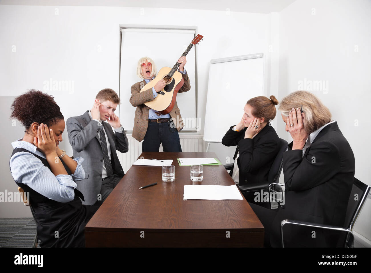 Imprenditore a suonare la chitarra nella riunione di affari Foto Stock