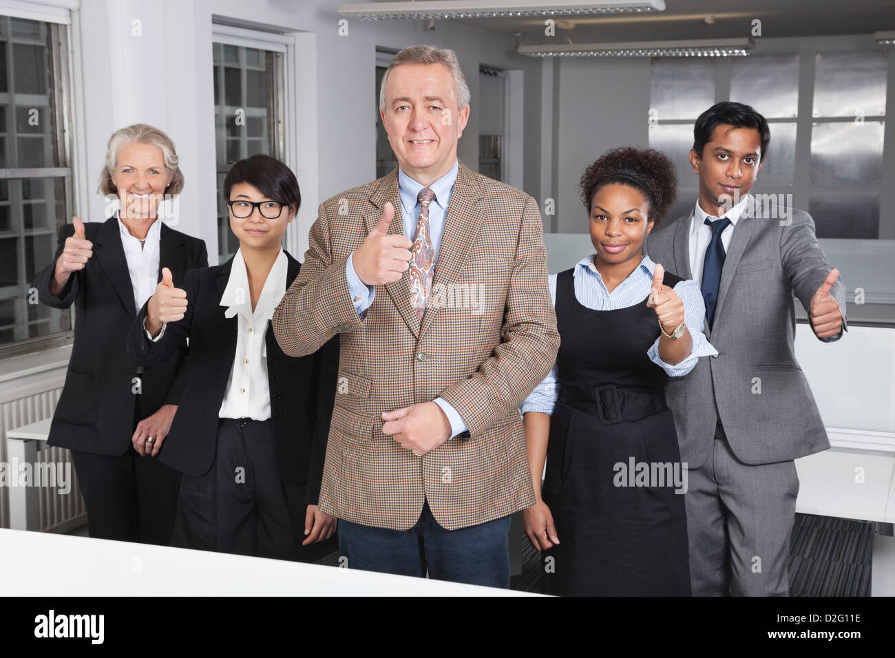 Ritratto di multietnica business group gesticolando pollice fino a office Foto Stock