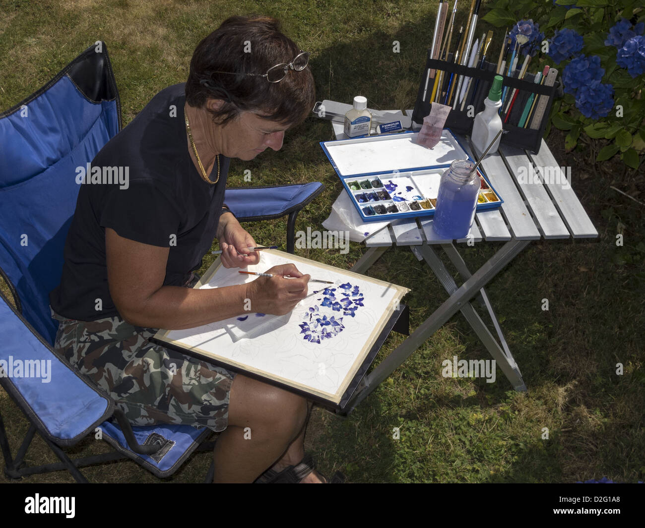 Donna seduta di verniciatura di un acquerello Foto Stock