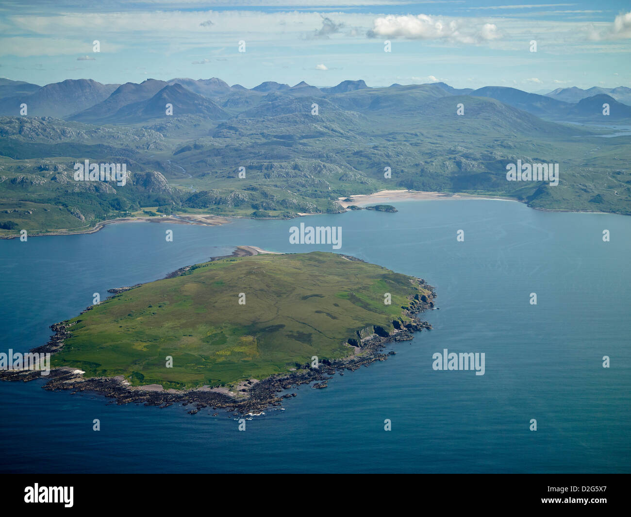 L'isola dell'antrace, l'isola di Gruinard e la baia dall'aria, la Scozia nord-occidentale, il Regno Unito, le montagne selvagge di Wester Ross dietro Foto Stock
