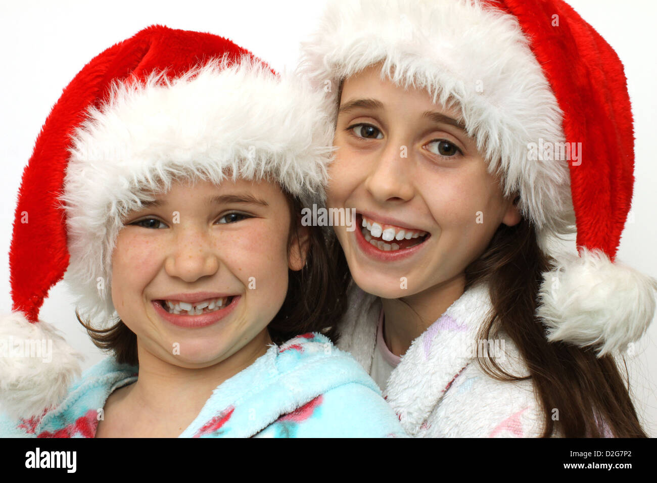 Due ragazze in cappelli di Babbo Natale entusiasti di Natale Foto Stock