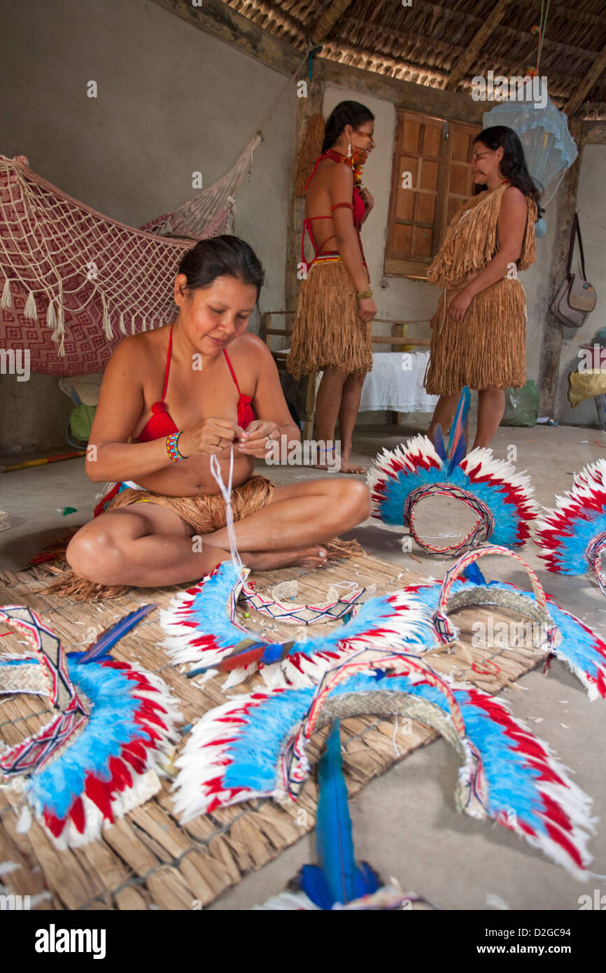 Donne indigene brasiliane Pataxo che fanno abiti tradizionali della testa da piume di pappagallo, Bahia, Brasile, Sud America Foto Stock