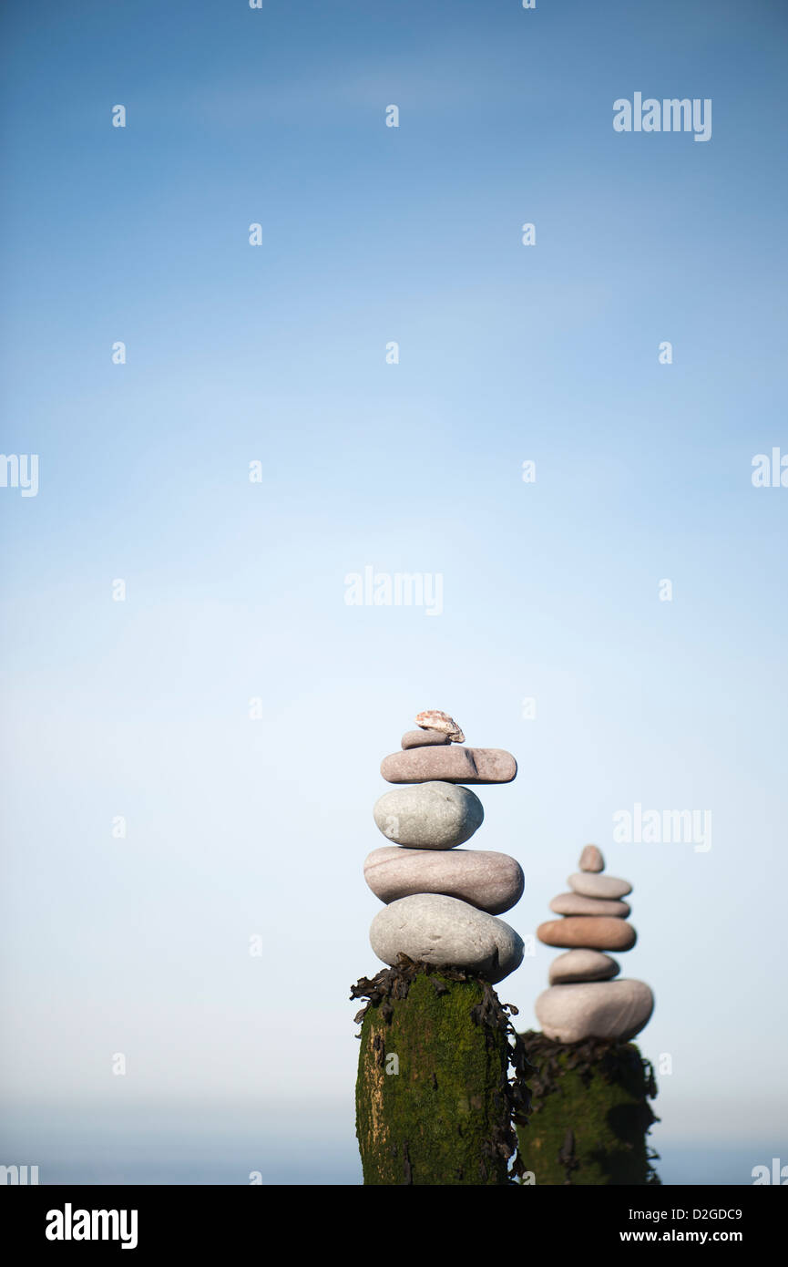Cataste di pietre sulla parte superiore di una tavola di legno groyne sulla spiaggia di Porlock Weir, Somerset, Inghilterra, Regno Unito Foto Stock