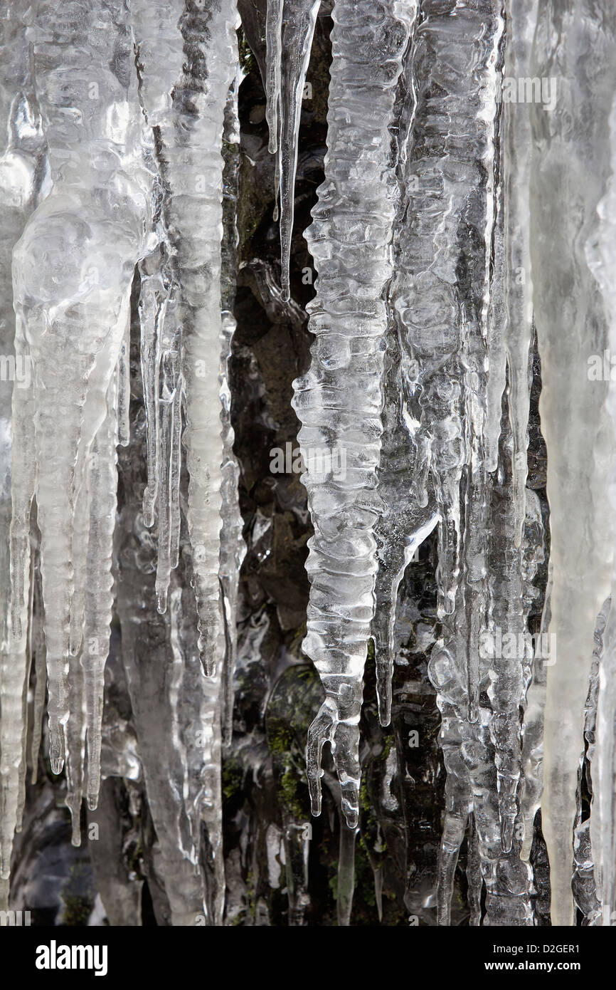 Ghiaccioli sul lato della grotta di montagna rocce in Sfondo Inverno Foto Stock
