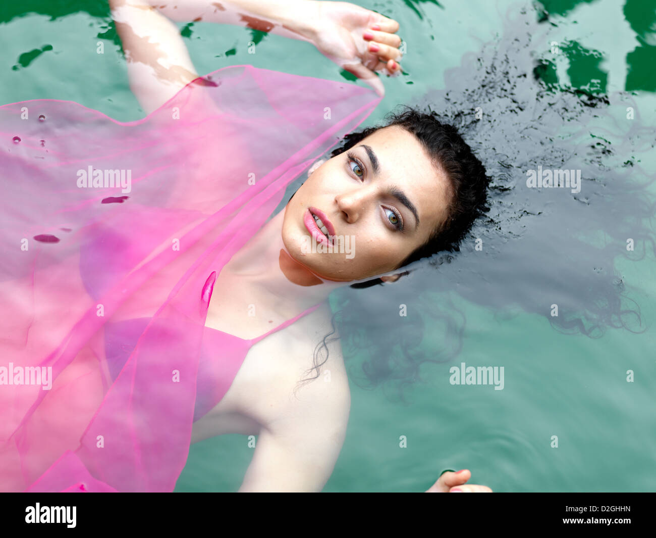 Donna flottante in una piscina sulla sua schiena Foto Stock