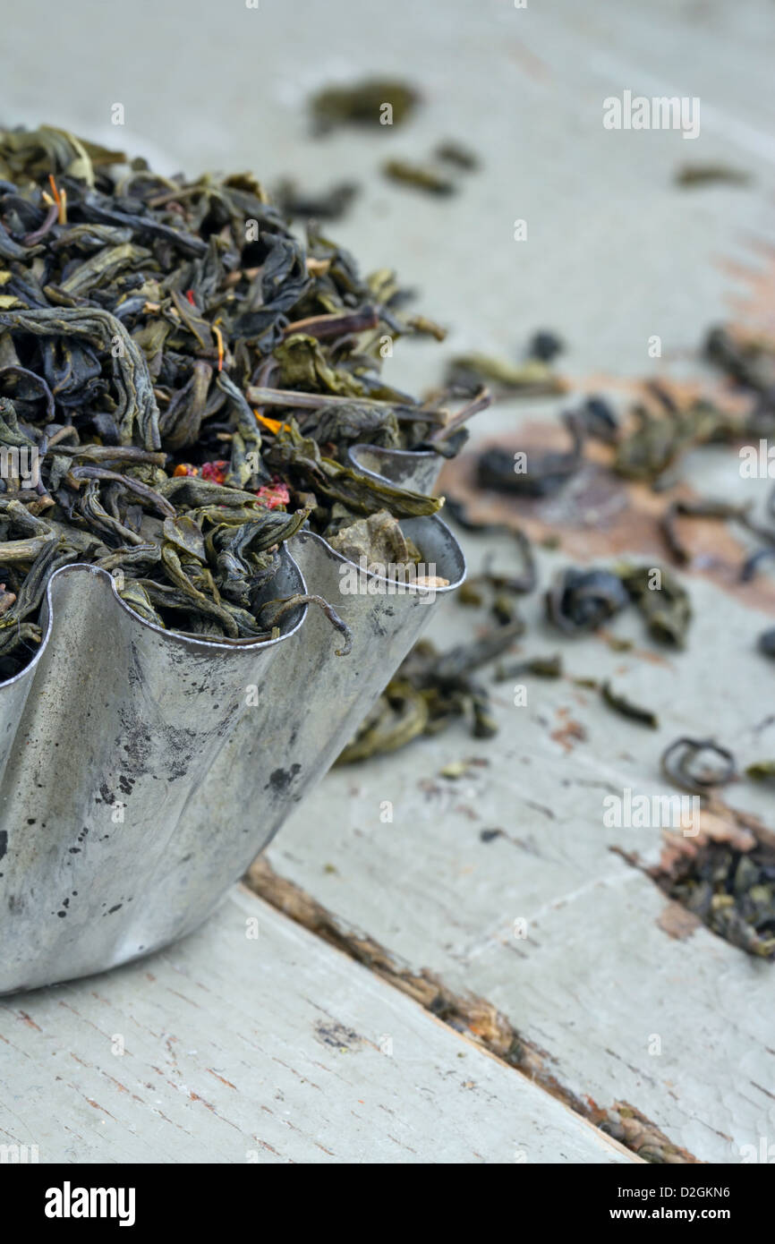 Asciugare di foglie di tè verde in una rustica tortina di metallo sul tavolo di legno Foto Stock