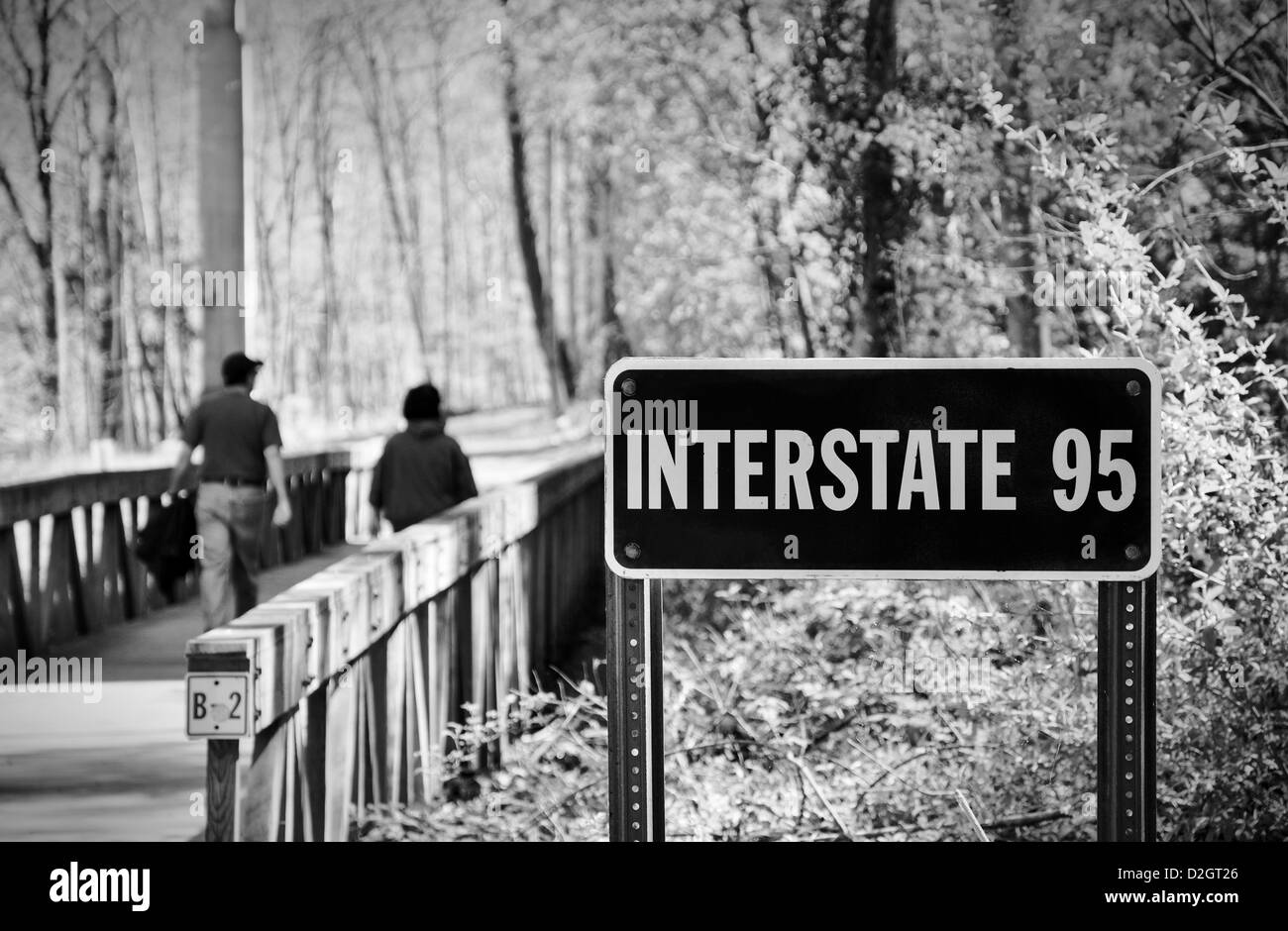 Un paio di camminare su un ponte al di sopra della pianura alluvionale del piccolo fiume Patuxent in Columbia, Maryland passando sotto la I-95 Foto Stock