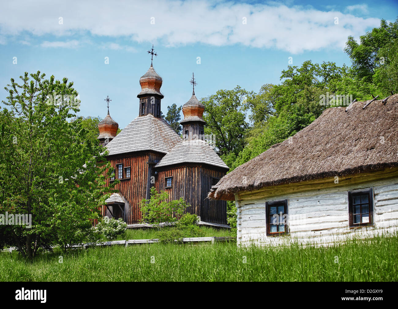 Tradizionale villaggio slavo di legno con la chiesa ortodossa e la casa con tetto di paglia Foto Stock