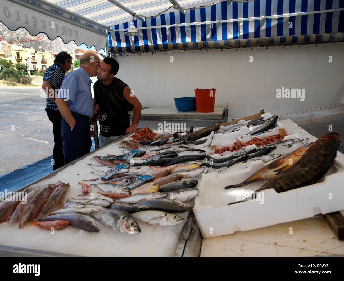 Sicilia Italia Mercato del Pesce a Porticello siciliani saluto ogni altro uomo baciare le guance di un amico Foto Stock