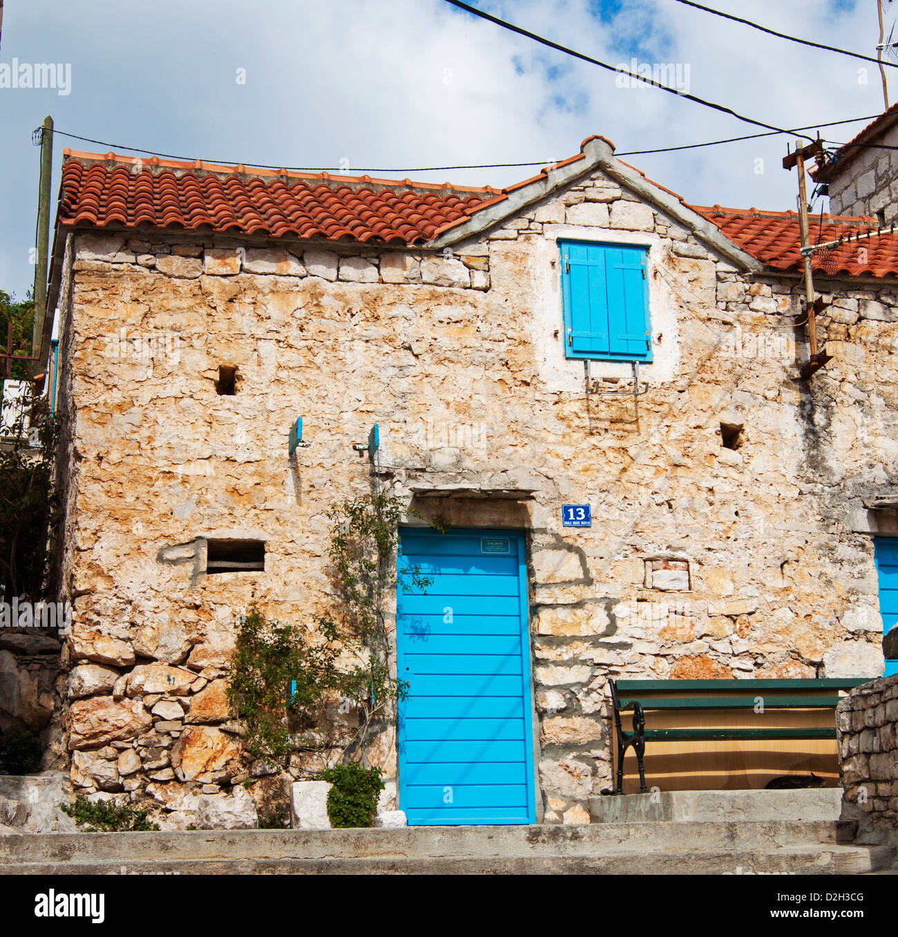 Un tradizionale vecchio cottage con blu turchese di porte e finestre nel villaggio di Maslinica, isola di Solta, Croazia Foto Stock