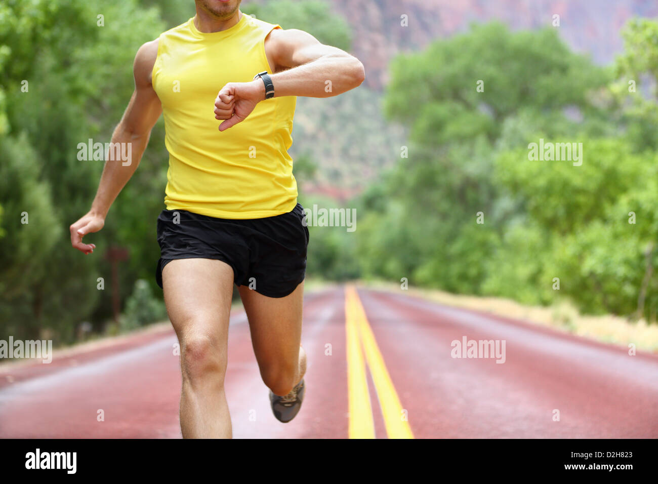 Runner con fascia cardio orologio sportivo al di fuori nella natura sulla strada. Foto Stock